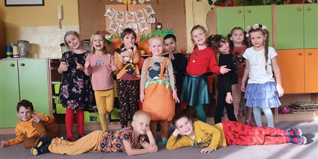 Powiększ grafikę: Grupa dzieci w pomarańczowych ubraniach w dzień dyni.