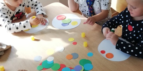 Powiększ grafikę: Dzieci ozdabiają koła kolorowymi kropkami.