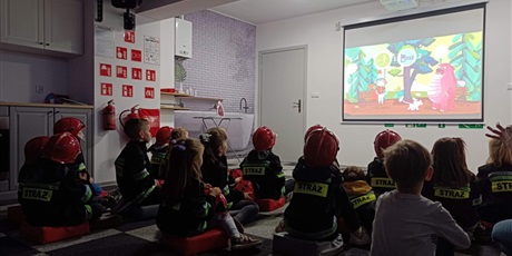 Powiększ grafikę: Dzieci oglądają film edukacyjny podczas zajęć.
