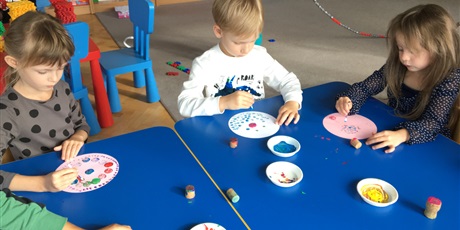 Powiększ grafikę: Dzieci malują kropki na kołach patyczkami kosmetycznymi i korkami.