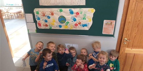 Powiększ grafikę: Dzieci na tle plakatu wykonanego z odbitych dłoni z okazji Dnia Praw Dziecka.