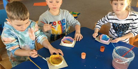 Powiększ grafikę: Dzieci malują farbami plakatowymi samodzielnie wykonane miseczki.