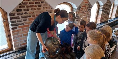 Powiększ grafikę: Dzieci patrzą na historyczny ubiór płetwonurka w muzeum.