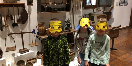 Powiększ grafikę: Dzieci ubrane w maski. W tle eksponaty muzeum etnograficznego.