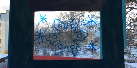 Powiększ grafikę: Witraż w oknie ukazujący śnieżynkę.